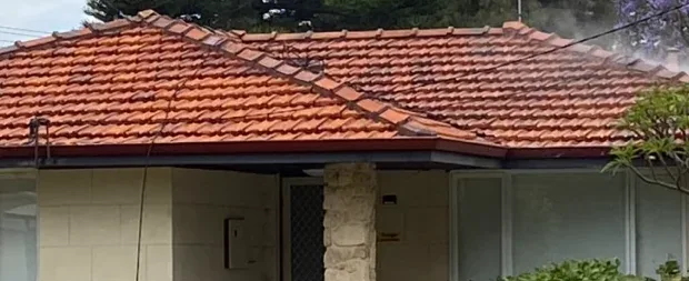 Street view of the same home with a freshly cleaned roof