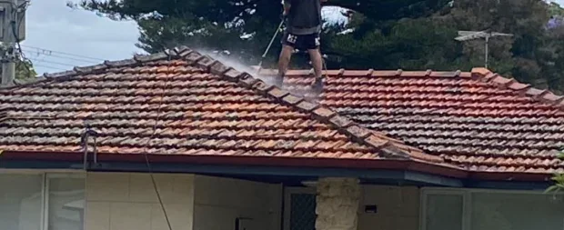 Street view of a home with a dirty, lichen covered tile roof