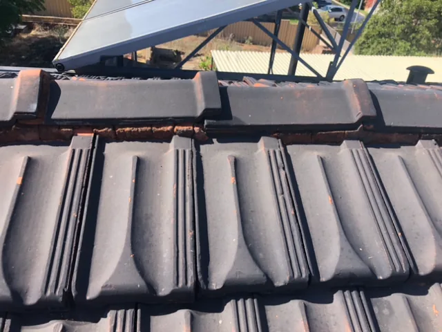Perished rust coloured pointing between charcoal ridge caps