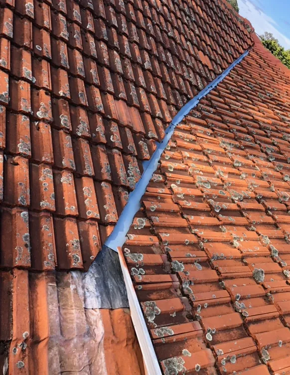 New valley flashing installed between two tiled roof sections