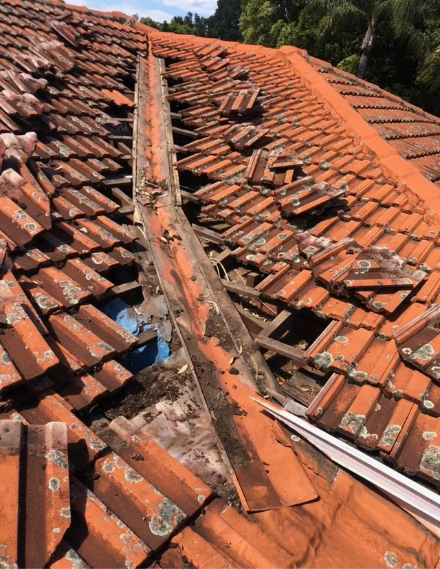 Roof tiles lifted showing the old rusted valley being removed